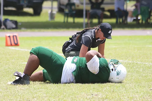 Florence Wasko tending to one of the many injured in Saturday's games, this time it is Cyan Fiatoa