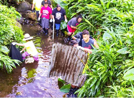 Youth volunteers remove scrap metal from the Vaitele stream 
